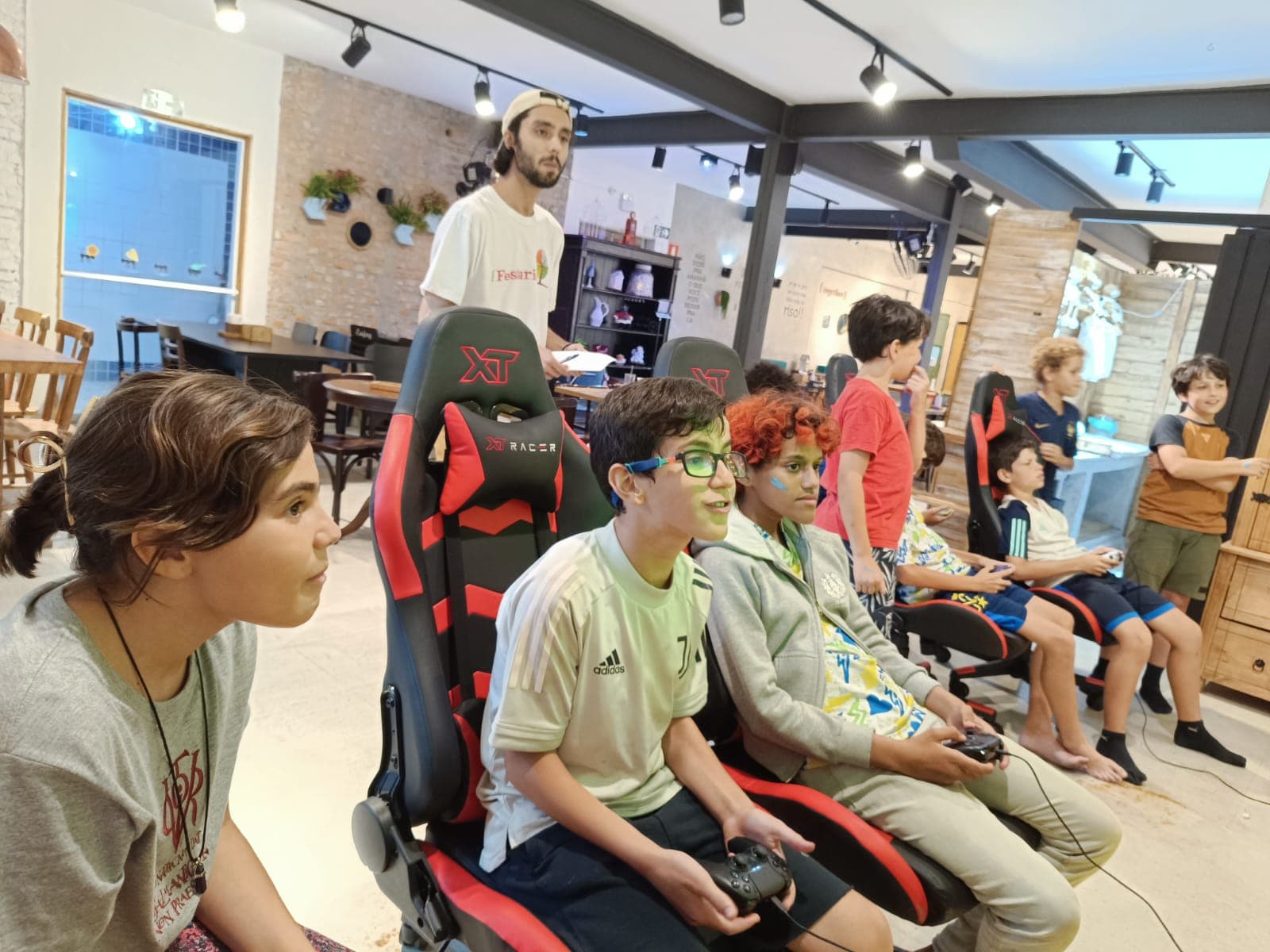 Participantes jogando em cadeiras gamer em evento